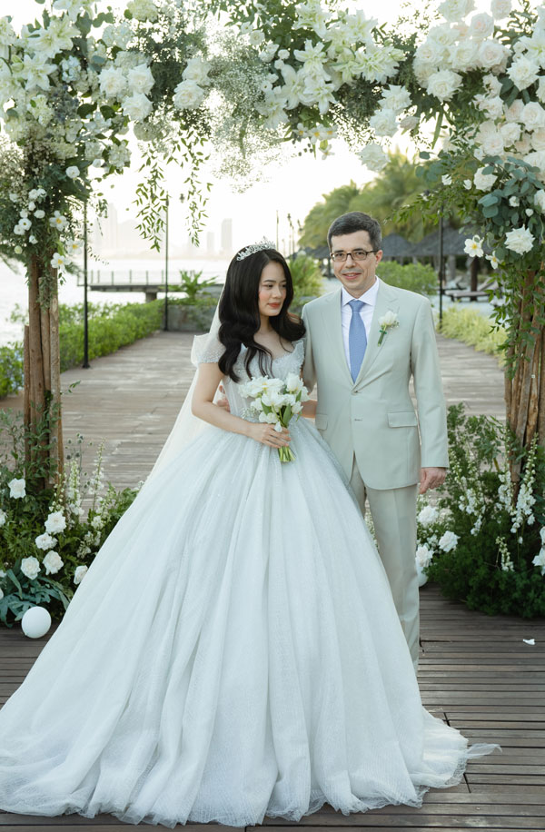 Bride and groom under the white flower arch on the timber deck at Amiana Resort Bride and groom under the white flower arch on the timber deck at Amiana Resort