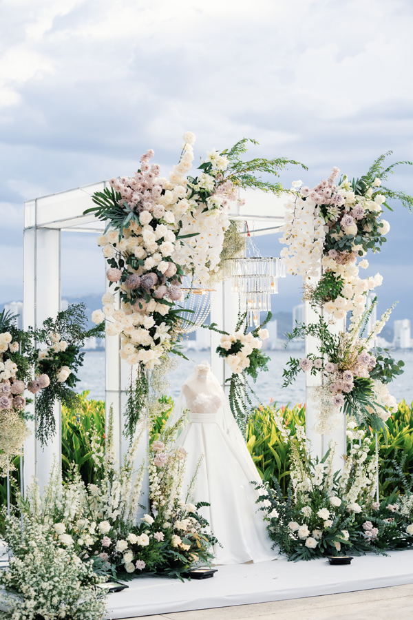 Nha Trang Wedding Resort Decor: Amiana and Alibu Ceremonies Wedding gown on a mannequin between pink and white flower pillars, crystal chandelier above