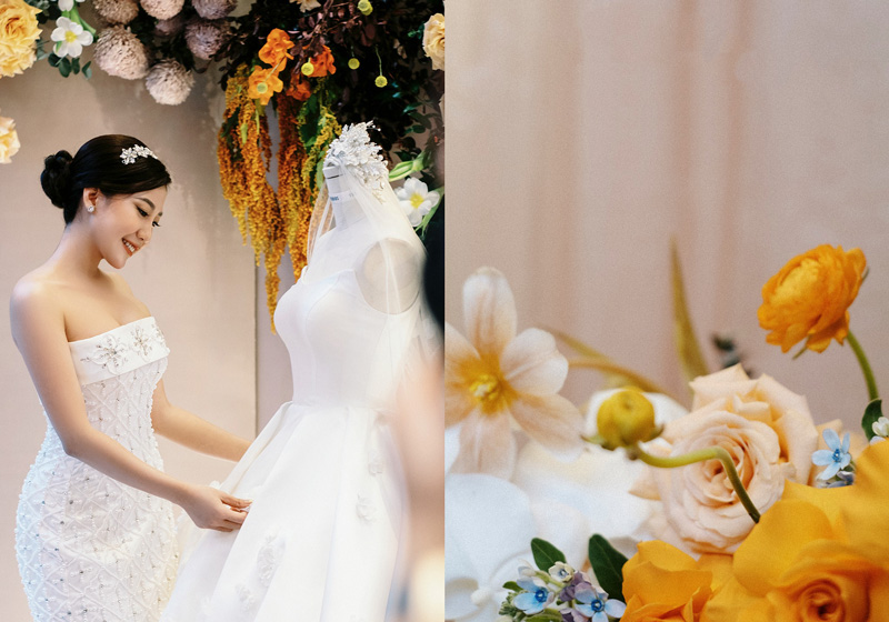 Cô dâu bên váy cưới giữa hoa hồng cam và lan trắng