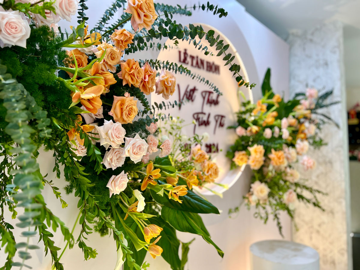 Cận cảnh hoa hồng cam, hồng phấn và loa kèn cam trên phông tròn lễ tân hôn Cận cảnh hoa hồng cam, hồng phấn và loa kèn cam trên phông tròn lễ tân hôn