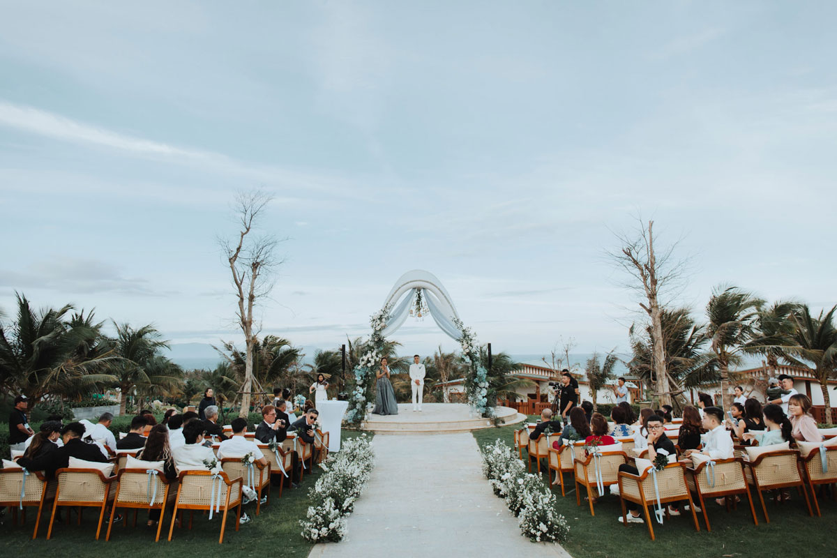 Wedding in Cam Ranh: Stunning Beach Vows and Resort Lawns Wide view of a lawn wedding at Mövenpick Resort Cam Ranh with guests seated and a couple under the dome