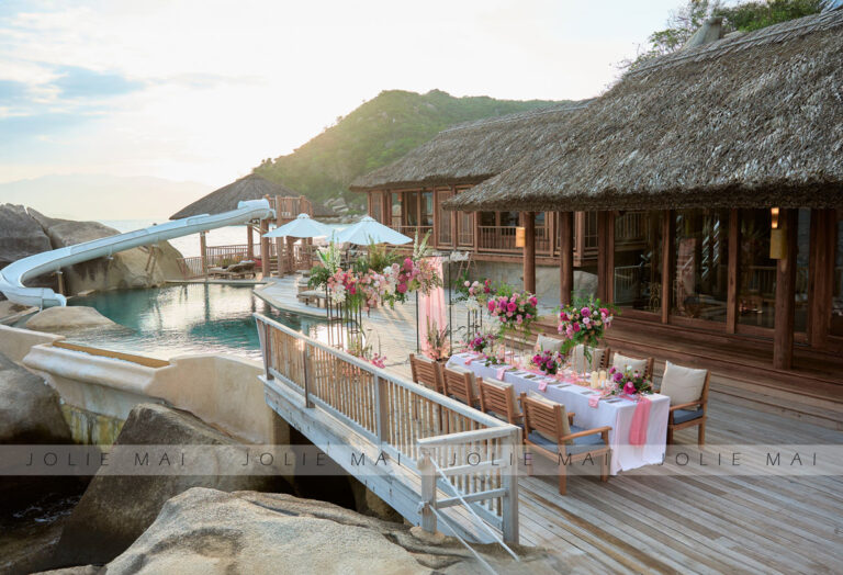 Bàn tiệc cưới hoa hồng trên sàn gỗ resort cạnh hồ bơi