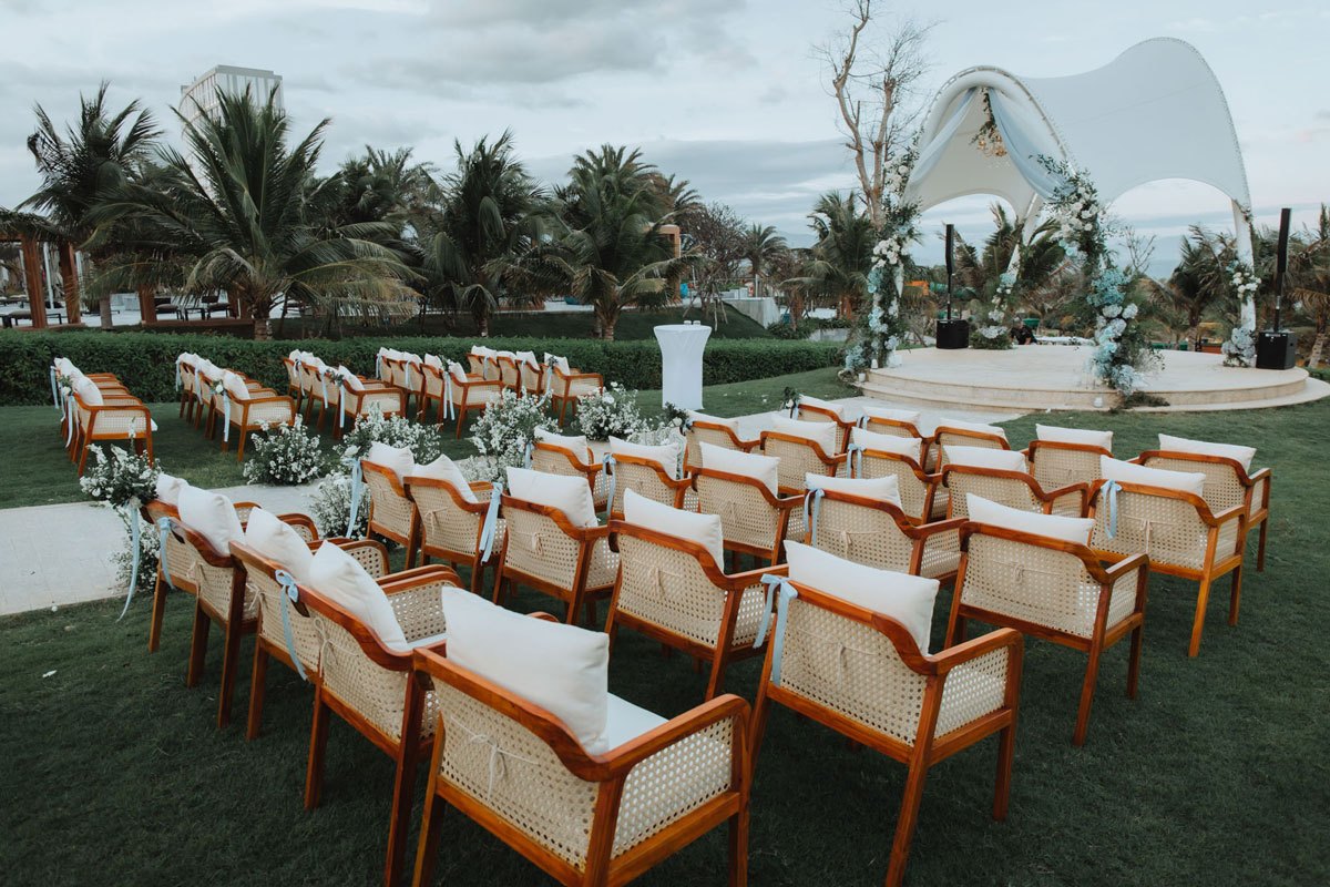 Ghế mây đệm trắng xếp hai khối trên bãi cỏ hướng về vòm trắng tại Mövenpick Resort Cam Ranh Ghế mây đệm trắng xếp hai khối trên bãi cỏ hướng về vòm trắng tại Mövenpick Resort Cam Ranh