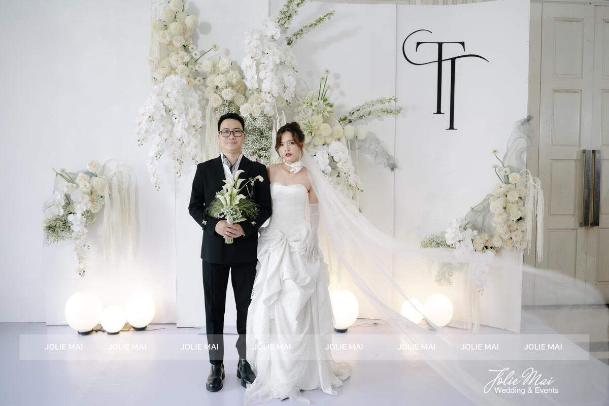 Chú rể cầm bó calla trắng và baby trước phông voan trắng và lan hồ điệp Chú rể cầm bó calla trắng và baby trước phông voan trắng và lan hồ điệp