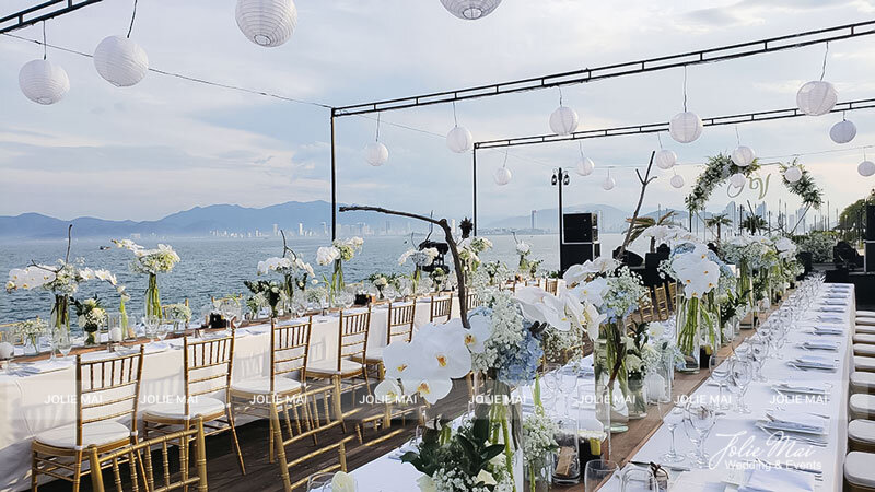 Bàn tiệc dài ghế vàng, lan trắng nhìn ra vịnh Nha Trang Bàn tiệc dài ghế vàng, lan trắng nhìn ra vịnh Nha Trang