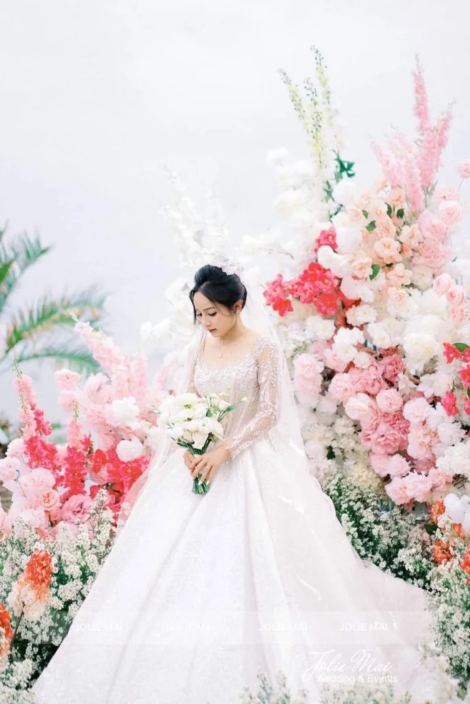Jolie Mai Wedding: 12 năm trang trí tiệc cưới tại Nha Trang Cô dâu bên cụm hoa lễ cưới trắng hồng tại Amiana Resort Nha Trang