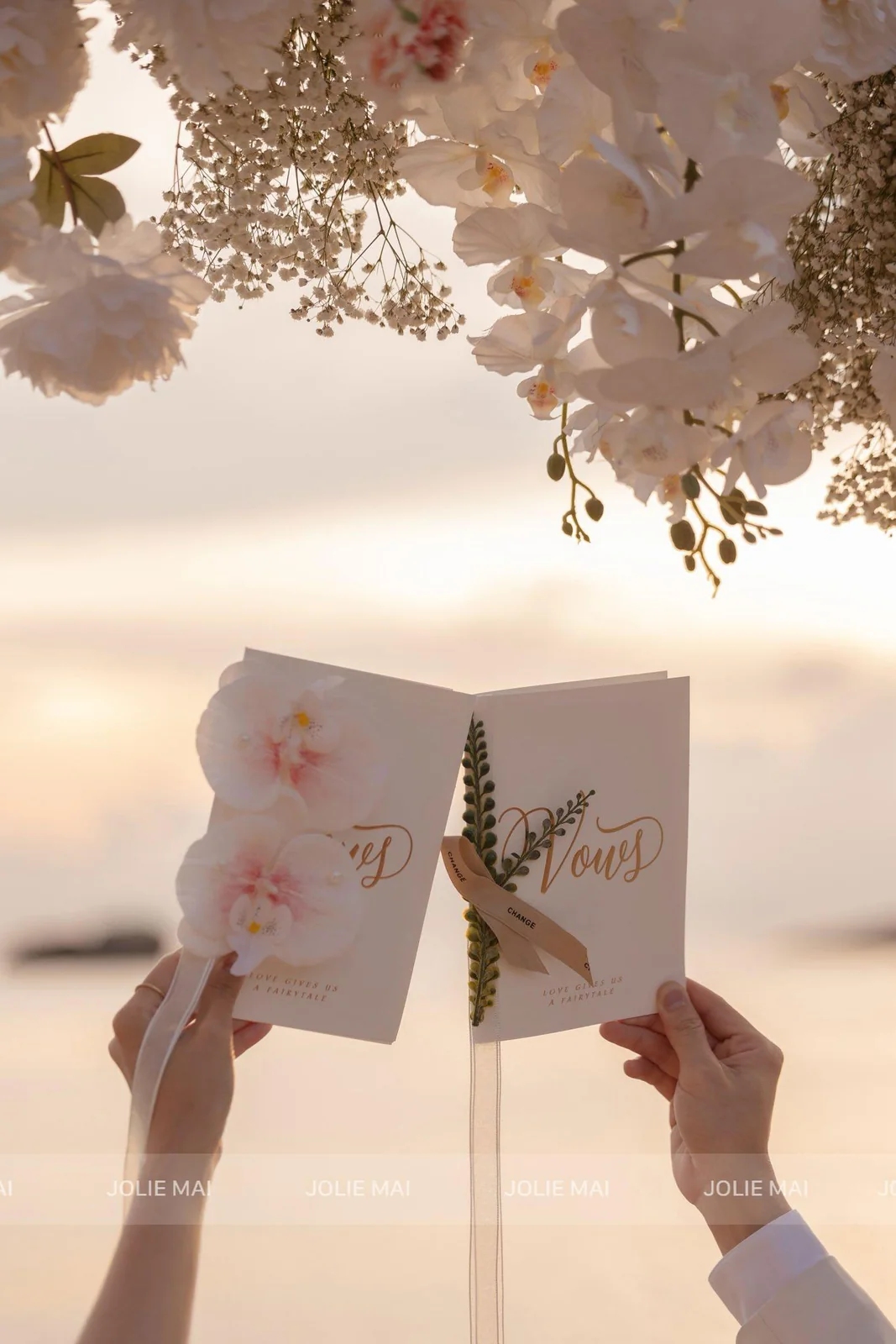 Hai quyển sổ lời thề bìa kem chữ Vows gắn lan hồ điệp và ruy băng Hai quyển sổ lời thề bìa kem chữ Vows gắn lan hồ điệp và ruy băng