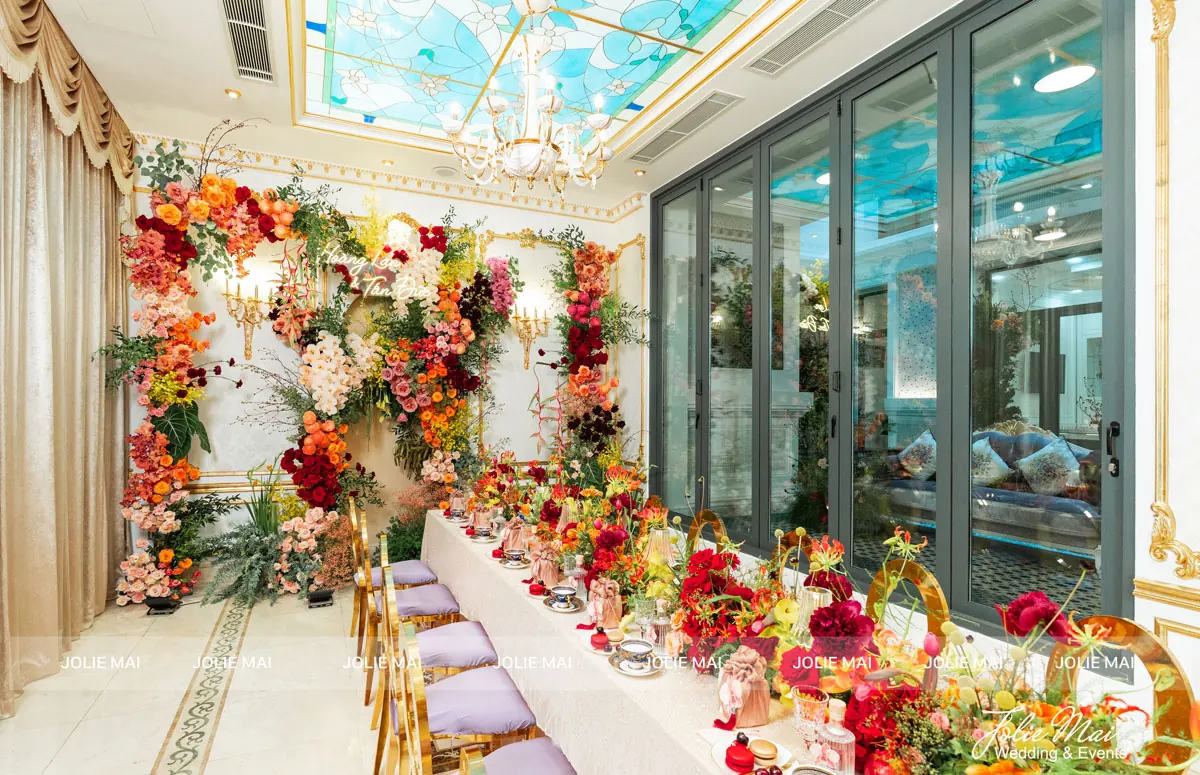 Trang Trí Gia Tiên Nha Trang: Hoa Lụa Từ 9,8 Triệu trang trí gia tiên Nha Trang lễ đính hôn: hai vách hoa cam đỏ, bàn hai họ dài ghế tím dưới trần kính màu