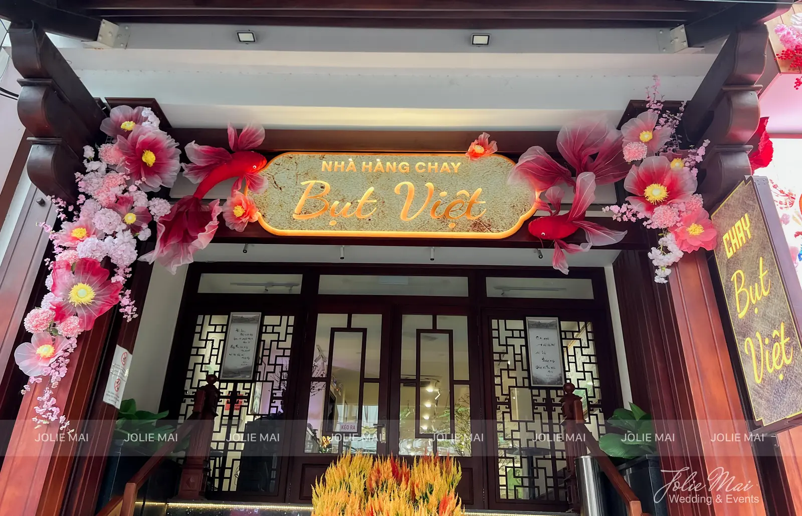 Cổng nhà hàng chay Bụt Việt trang trí Tết hoa vải và cá organza Cổng nhà hàng chay Bụt Việt trang trí Tết hoa vải và cá organza